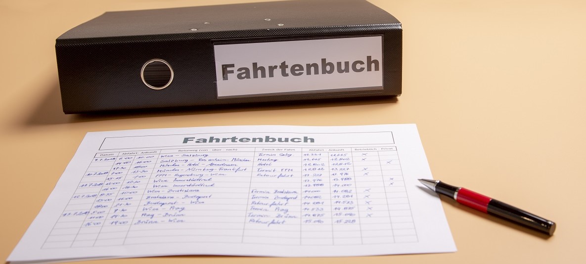 Fahrtenbuch mit Blatt und Kugelschreiber Fahrtenbuch mit Blatt und Kugelschreiber davor